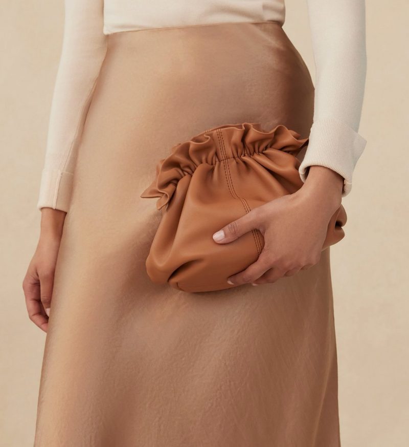 model holding tan leather clutch bag by loeffler randall